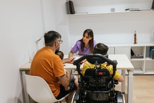 family with child with physical disabilities talking to doctor